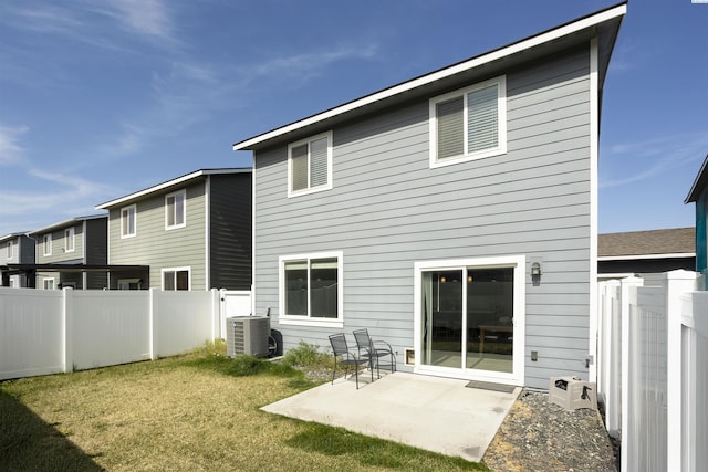 rear view of property with central AC, a fenced backyard, a patio, and a yard