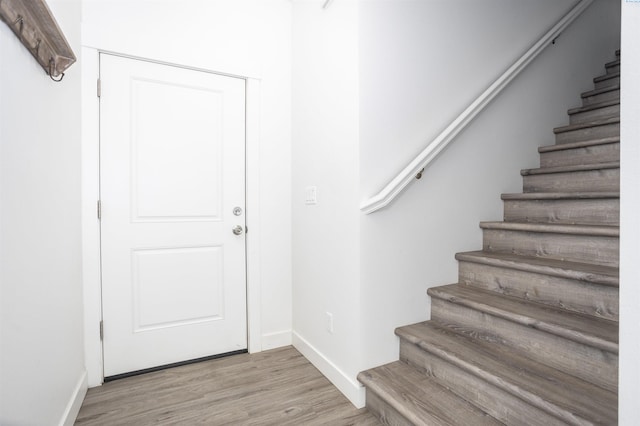 stairway with baseboards and wood finished floors