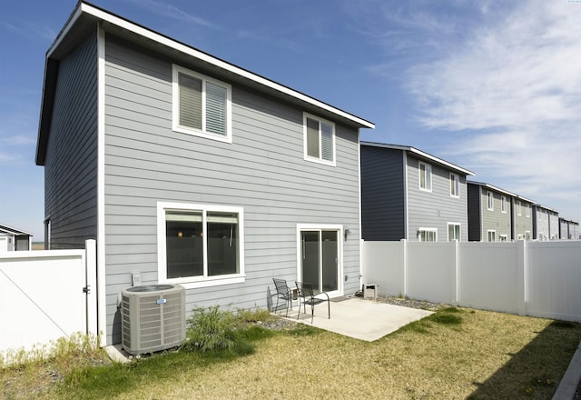 rear view of property featuring a fenced backyard, cooling unit, a patio, and a lawn
