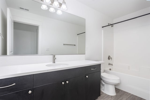 full bath featuring vanity, shower / washtub combination, toilet, visible vents, and wood finished floors