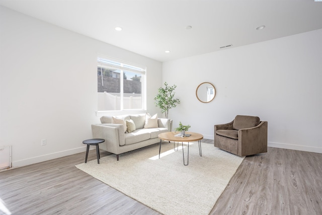 living room featuring light wood finished floors, baseboards, visible vents, and recessed lighting