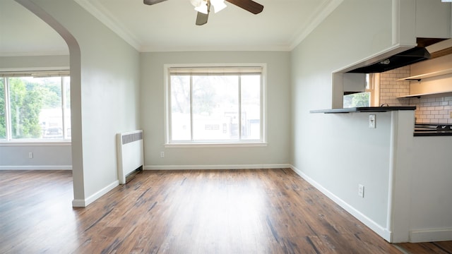 201 W Cooper St, Colfax, WA 99111 - unfurnished living room with radiator heating unit, a ceiling fan, arched walkways, wood finished floors, and crown molding