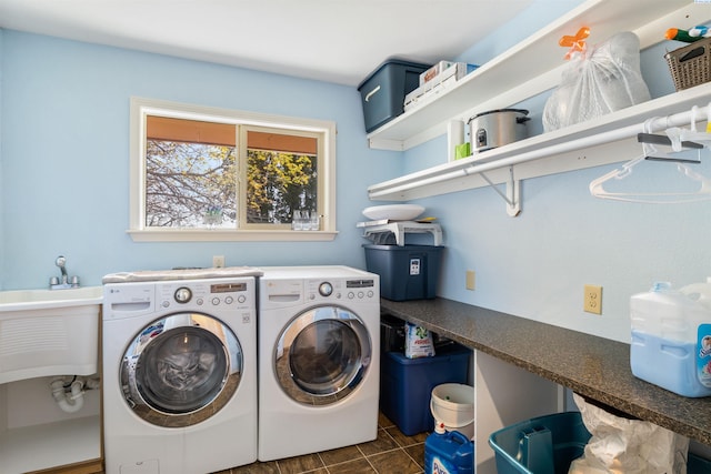 laundry room with dark tile patterned floors and washing machine and dryer