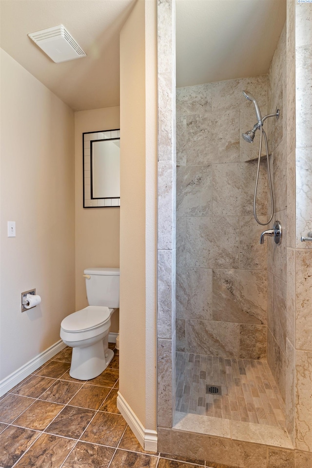 bathroom featuring tiled shower and toilet