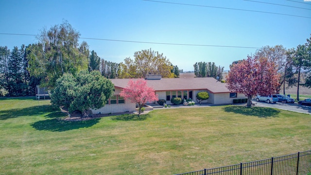 ranch-style house with a front lawn and a trampoline