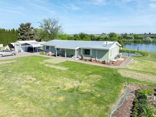 3680 E Euclid Rd, Mabton, WA 98935 - back of property featuring a detached carport, a lawn, a water view, and metal roof