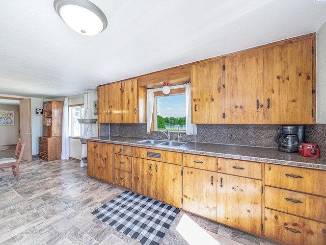 3680 E Euclid Rd, Mabton, WA 98935 - kitchen featuring a sink, backsplash, brown cabinetry, and dark countertops
