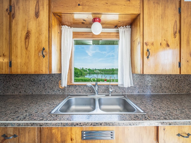 3680 E Euclid Rd, Mabton, WA 98935 - kitchen with a sink, dark countertops, brown cabinetry, and backsplash