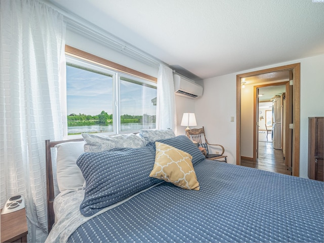 3680 E Euclid Rd, Mabton, WA 98935 - bedroom featuring an AC wall unit, wood finished floors, and a textured ceiling