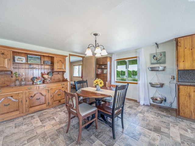 3680 E Euclid Rd, Mabton, WA 98935 - dining space with a chandelier, stone finish flooring, and baseboards