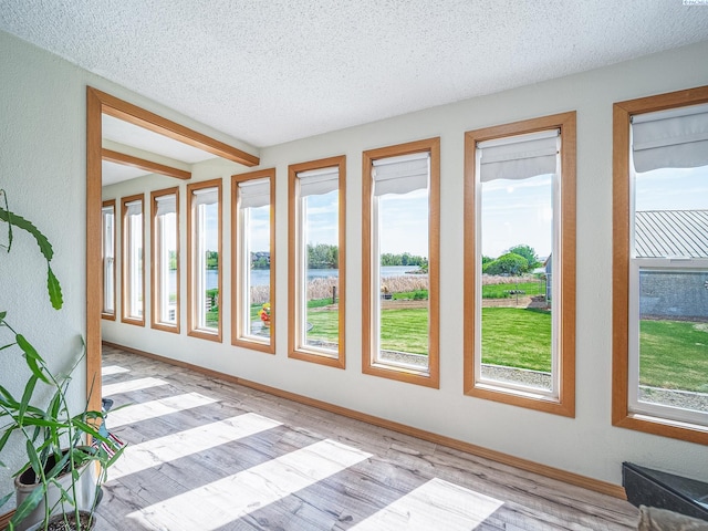 3680 E Euclid Rd, Mabton, WA 98935 - unfurnished sunroom with a water view, a textured ceiling, wood finished floors, and baseboards