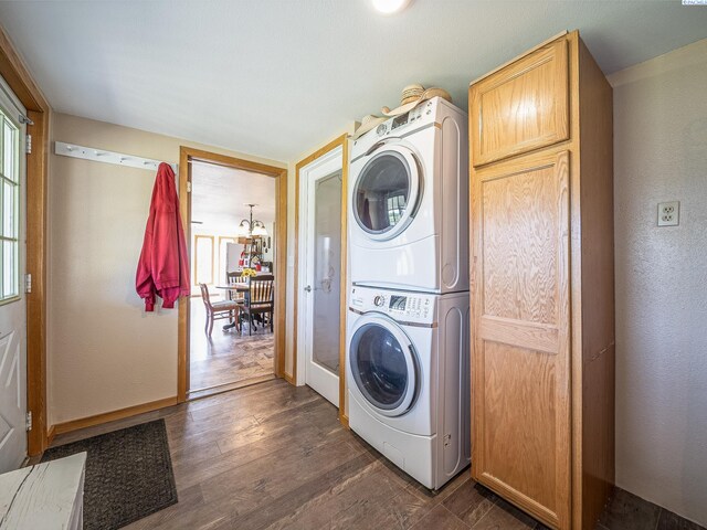 3680 E Euclid Rd, Mabton, WA 98935 - laundry area featuring stacked washer and clothes dryer, cabinet space, a chandelier, dark wood finished floors, and a textured wall