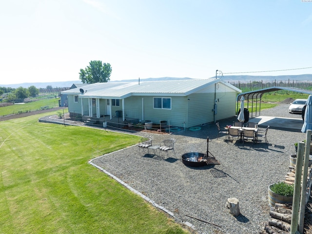 3680 E Euclid Rd, Mabton, WA 98935 - rear view of property with a lawn, metal roof, and a detached carport