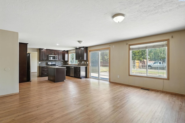 4505 S Dayton Ct, Kennewick, WA 99337 - kitchen featuring appliances with stainless steel finishes, light wood-style flooring, tasteful backsplash, and dark brown cabinets