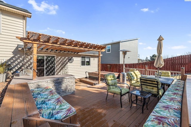 wooden deck with outdoor dining area, fence, and a pergola