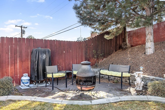 view of patio featuring a fenced backyard and a fire pit