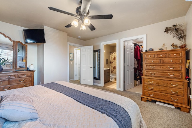 bedroom with light colored carpet, ensuite bath, ceiling fan, a spacious closet, and a closet