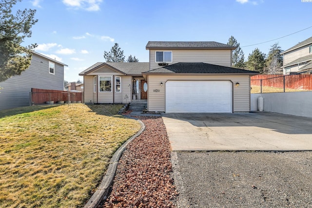 traditional home with an attached garage, fence, concrete driveway, and a front yard