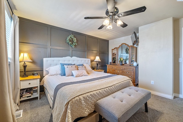 bedroom featuring carpet floors, a decorative wall, and ceiling fan