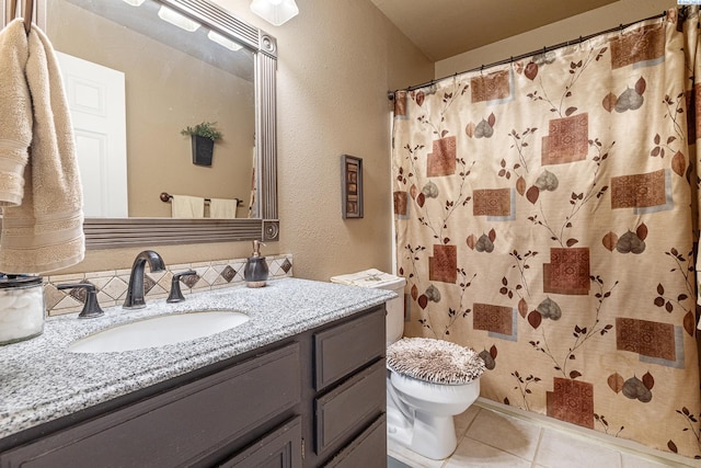 bathroom featuring toilet, a shower with curtain, vanity, and tile patterned floors