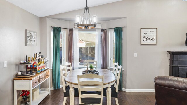 dining space with an inviting chandelier, dark hardwood / wood-style flooring, and vaulted ceiling