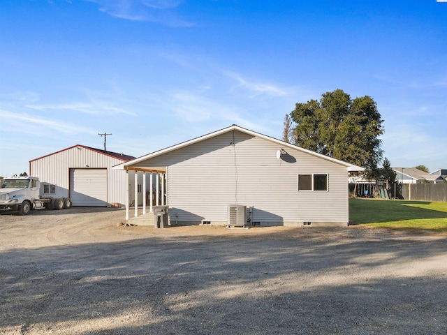 view of home's exterior with an outbuilding, central AC unit, and a garage