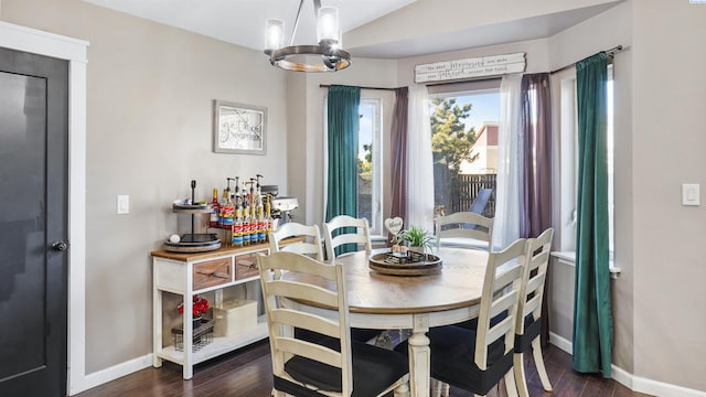 dining space featuring lofted ceiling, a notable chandelier, and dark hardwood / wood-style floors