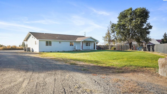 view of front of property featuring central AC, a playground, and a front lawn