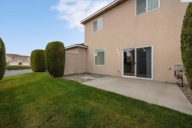 rear view of house with a patio and a lawn