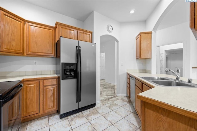 kitchen with appliances with stainless steel finishes, sink, and light tile patterned floors