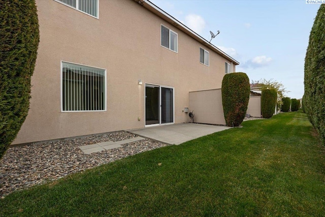 back of house with a lawn and a patio area