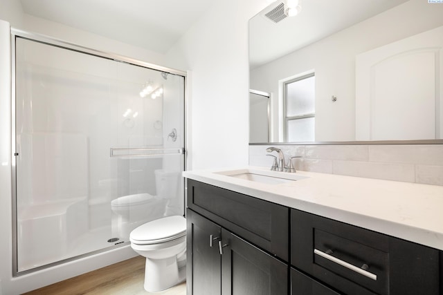 6562 W 30th Pl, Kennewick, WA 99338 - bathroom featuring toilet, a shower stall, vanity, wood finished floors, and decorative backsplash