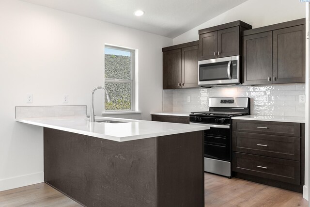 6562 W 30th Pl, Kennewick, WA 99338 - kitchen featuring appliances with stainless steel finishes, a sink, lofted ceiling, backsplash, and light wood-type flooring