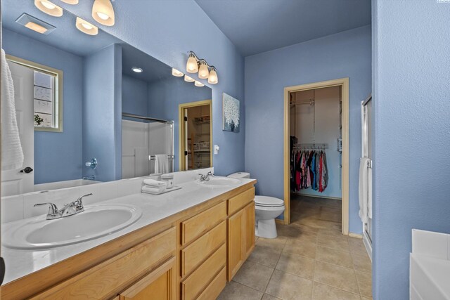 full bathroom featuring a sink, tile patterned flooring, double vanity, and a shower