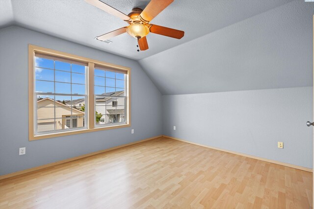 bonus room featuring a ceiling fan, baseboards, wood finished floors, lofted ceiling, and visible vents