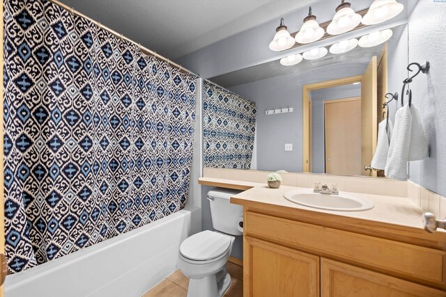 full bathroom with toilet, tile patterned floors, shower / bath combo with shower curtain, and vanity