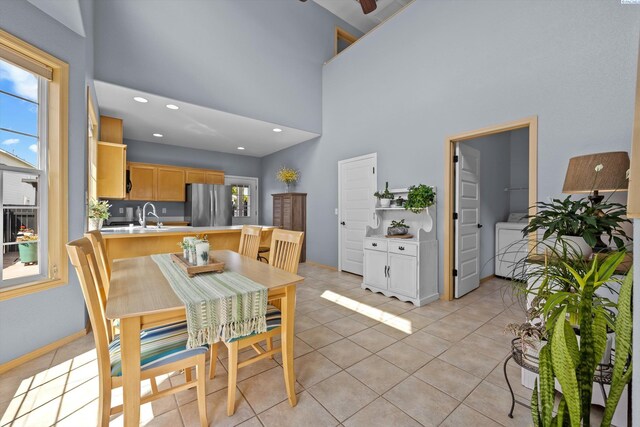 dining space featuring light tile patterned flooring, a high ceiling, washer / clothes dryer, recessed lighting, and baseboards
