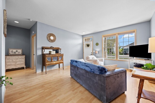 living area with recessed lighting and light wood-style flooring