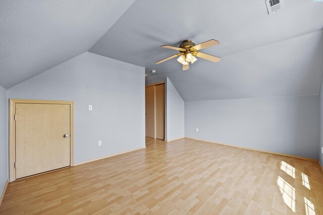 bonus room with a ceiling fan, visible vents, light wood finished floors, and lofted ceiling