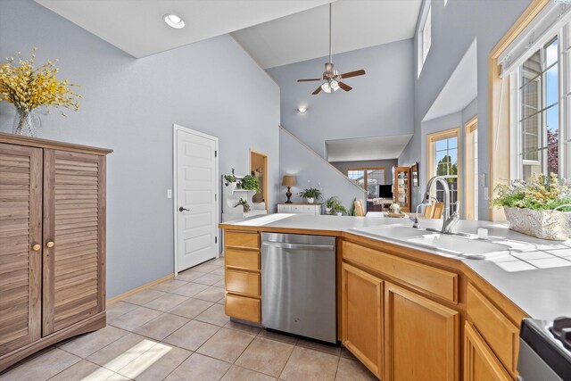 kitchen with appliances with stainless steel finishes, a sink, light countertops, high vaulted ceiling, and light tile patterned floors