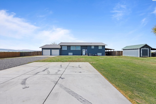 view of front of property with gravel driveway, a front lawn, fence, and a garage