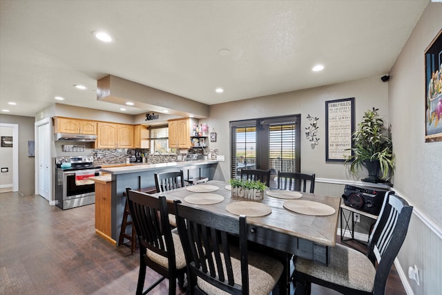 dining room with dark wood-type flooring, recessed lighting, and wainscoting