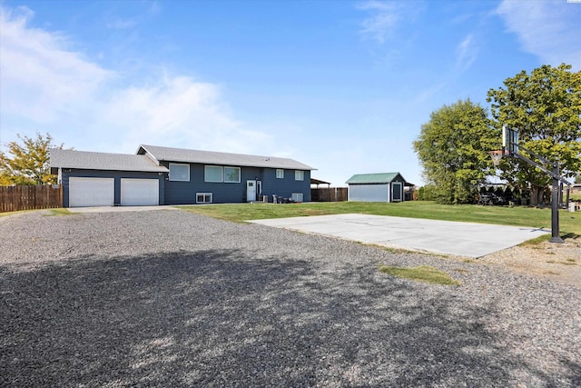 view of front of property featuring a garage, gravel driveway, a front lawn, and fence