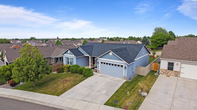 1905 S Harrison St, Kennewick, WA 99338 - view of front of house with stone siding, a residential view, concrete driveway, and an attached garage
