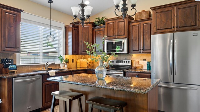 1905 S Harrison St, Kennewick, WA 99338 - kitchen featuring appliances with stainless steel finishes, a sink, backsplash, a center island, and decorative light fixtures