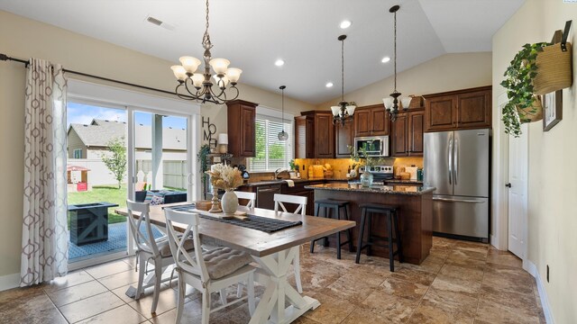 1905 S Harrison St, Kennewick, WA 99338 - dining room featuring a chandelier, vaulted ceiling, baseboards, and recessed lighting