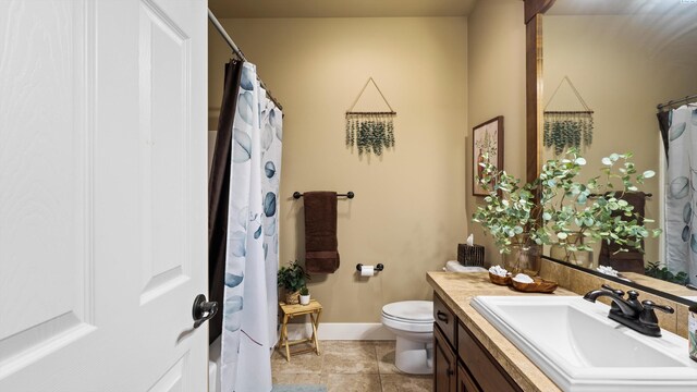 1905 S Harrison St, Kennewick, WA 99338 - full bath featuring toilet, vanity, baseboards, and a shower with shower curtain