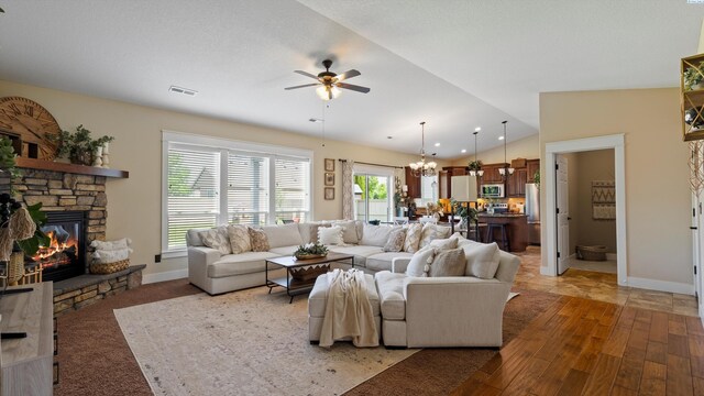 1905 S Harrison St, Kennewick, WA 99338 - living room featuring a chandelier, vaulted ceiling, ceiling fan, a fireplace, and baseboards