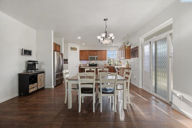 dining room featuring baseboards, dark wood-type flooring, visible vents, and an inviting chandelier