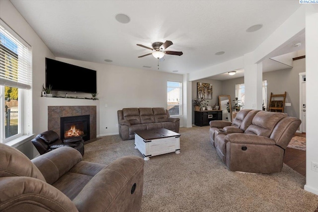 living area featuring carpet floors, a wealth of natural light, and a tile fireplace